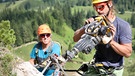 Bergsteiger arbeiten mit einer Bohrmaschine an einem Klettersteig | Bild: BR/Kilian Neuwert