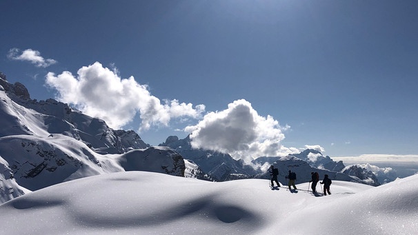 Gruppe von Tourengehern in tief verschneiter Berglandschaft | Bild: BR/Kathrin Denk 