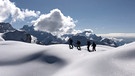 Gruppe von Tourengehern in tief verschneiter Berglandschaft | Bild: BR/Kathrin Denk 