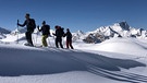 Gruppe von Tourengehern in tief verschneiter Berglandschaft | Bild: BR/Kathrin Denk 