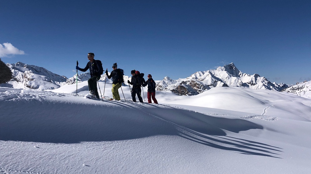 Gruppe von Tourengehern in tief verschneiter Berglandschaft | Bild: BR/Kathrin Denk 