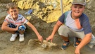 2 Kinder, die bei Langenpreising, 10 Millionen Jahre alte Ur-Elefanten gefunden haben und mit ihrem Fund posieren. | Bild: BR