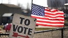 US-Wahl: Wahl-Schild und US-Flagge in Dearborn, Michigan | Bild: picture alliance/dpa/AP/Paul Sancya