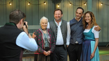 Dahoam is Dahoam: Geburtstagskind Theresa posiert mit ihrer Familie für ein Foto. Von links: Ludwig (Martin Wenzl), Theresa (Ursula Erber), Gregor (Holger Matthias Wilhelm), Mike (Harry Blank), Annalena (Heidrun Gärtner). | Bild: BR/Marco Orlando Pichler