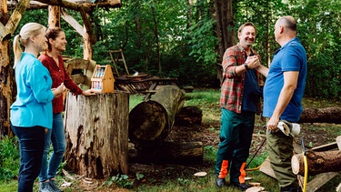 Dahoam is Dahoam: Gregor und Hubert treten im Ausscheidungskampf im Baumsägen gegeneinander an. Von links: Vera (Sybille Waury), Annalena (Heidrun Gärtner), Gregor (Holger Mathias Wilhelm), Hubert (Bernhard Ulrich). | Bild: BR/Nadya Jakobs