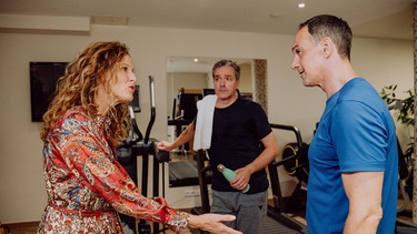 Dahoam is Dahoam: Mike (Harry Blank) und Annalena (Heidrun Gärtner) streiten, weil Mike ihr romantisches Dinner vergessen hat. Im Hintergrund: Hotelgast Herbert Bock (Fritz Barth). | Bild: BR/Nadya Jakobs