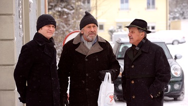 Martin beginnt einen Spießrutenlauf, als die Lansinger ihm das Renn-Ergebnis unterreiben wollen. Von links: Ludwig Brunner (Martin Wenzl), Martin Kirchleitner (Hermann Giefer) und Bürgermeister Schattenhofer (Werner Rom). | Bild: BR/Marco Orlando Pichler