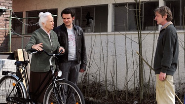 Theres findet ihr Fahrrad in Alois Versteck. Von links: Theresa (Ursula Erber), Florian Brunner (Tommy Schwimmer) und Xaver (Michael Schreiner). | Bild: BR/Marco Orlando Pichler