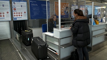 Eine Urlauberin gibt am Flughafen Nürnberg ihren Koffer auf. | Bild: BR