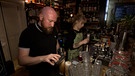 Barkeeper in der Bar "Das Schwarze Schaf" bei der Arbeit. | Bild: BR