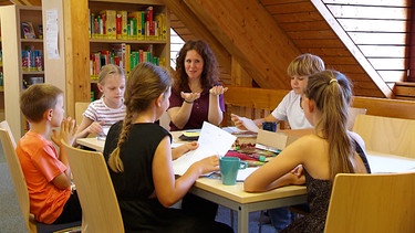 Eine Bibliothek-Mitarbeiterin bei einer Lesestunde mit Kindern. | Bild: BR