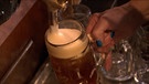 Frau schenkt Bier aus. | Bild: BR