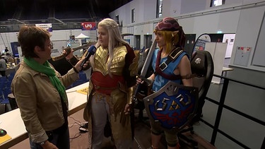 BR-Korrespondentin Annerose Zuber im Gespräch mit zwei Cosplayerinnen auf der Gaming-Messe. | Bild: BR
