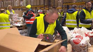 Menschen verpacken Lebkuchen für Bedürftige. | Bild: BR