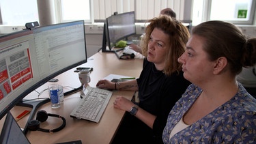 Zwei Frauen schauen in einen Computerbildschirm. | Bild: BR