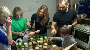 Familie verpackt Duftkerzen. | Bild: BR