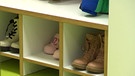 Eine Garderobe in einer Kita mit Schuhen von Kindern. | Bild: BR