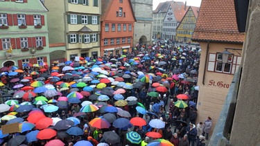 Hunderte Menschen bei der Mahnwache mit Regenschirmen. | Bild: BR