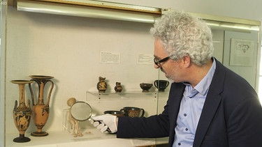 Museumsleiter zeigt Erbstücke. | Bild: BR