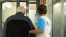 Frau mit Rentner am Eingang einer Tagespflege. | Bild: BR