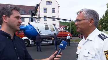 Christoph Schneider  im Interview mit einem Polizisten. | Bild: BR