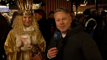 BR-Korrespondent Tobi Burkert auf dem Nürnberger Christkindlesmarkt mit dem Christkind. | Bild: BR