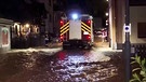 Feuerwehrauto in überfluteter Straße. | Bild: BR