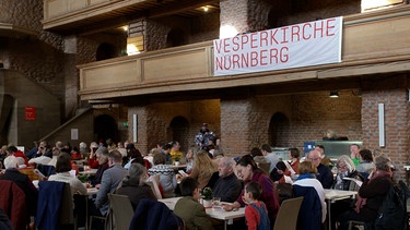 Menschen gemeinsam in der Vesperkirche in Nürnberg. | Bild: BR