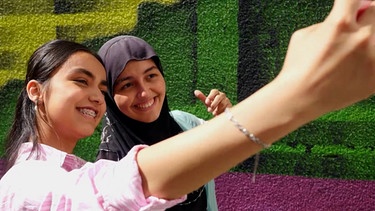 Mina und Masuma machen zusammen ein Selfie. | Bild: BR