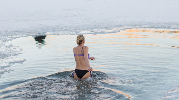 Frau badet im Winter im See.  | Bild: stock.adobe.com/Hanna