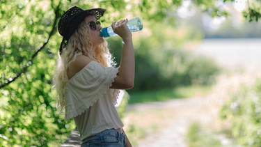 Hut, Trinken, Schatten: Eine junge Frau kämpft gegen die Sommerhitze. | Bild: BR/Sylvia Bentele