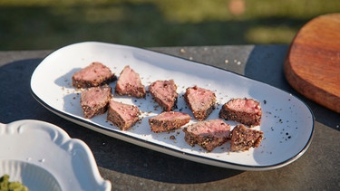 Köchin Ivana Austermayr und Schauspieler und Hobbykoch Adnan Maral zeigen Steak mit Pfefferkruste. | Bild: BR/Yalla Productions GmbH/Marian Mok