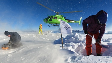 Klimaforscher am Gletscher mit Bohrkern.  | Bild: BR