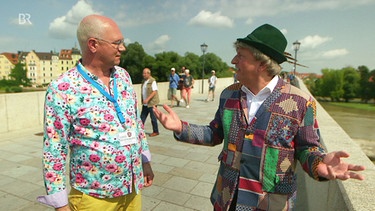 Volker Heißmann (rechts) und Martin Rassau sind als Stadtführer auf der Steinernen Brücke in Regensburg unterwegs. | Bild: BR