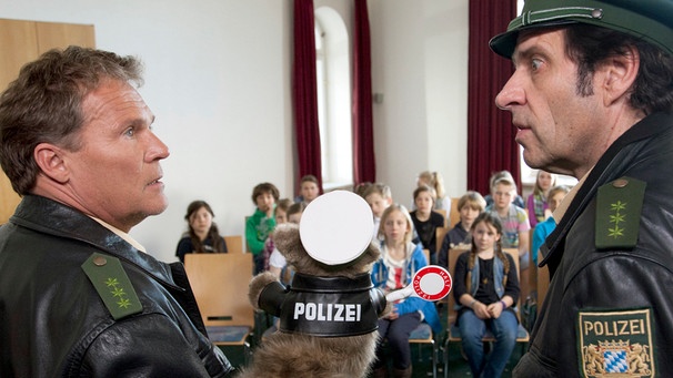 Spezialeinsatz im Schullandheim: Hubert (Christian Tramitz, links) und Staller (Helmfried von Lüttichau) erklären einer Schulklasse mit einer Handpuppe die Verkehrsregeln. | Bild: ARD/BR/TMG/Chris Hirschhäuser