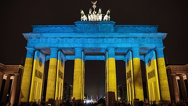 Angestrahltes Brandenburger Tor in den ukrainischen Nationalfarben als Zeichen der Solidaritaet und gegen den Krieg Russlands in der Ukraine. | Bild: picture alliance / SZ Photo | Olaf Schülke