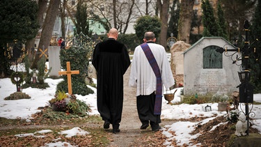 Zwei Geistliche auf einem Münchner Friedhof. | Bild: picture alliance / SZ Photo | Alessandra Schellnegger