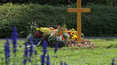 Grab mit Holzkreuz auf einem Friedhof | Bild: picture alliance / SVEN SIMON | Frank Hoermann / SVEN SIMON