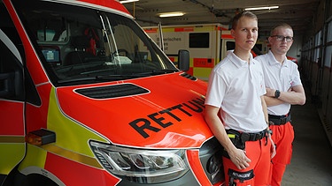 Rettungssanitäter vor einem Krankenwagen | Bild: BR