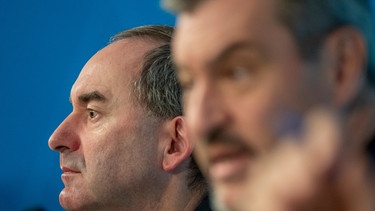 Hubert Aiwanger, (l, Freie Wähler) Stellvertretender Ministerpräsident und bayerischer Wirtschaftsminister, sitzt neben Markus Söder, (r, CSU) Ministerpräsident von Bayern, auf der Pressekonferenz zur Haushaltsklausur des bayerischen Kabinetts. | Bild: picture alliance/dpa | Peter Kneffel