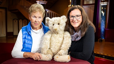 Das Expertenteam von "Kunst + Krempel" in der Musikhalle Ludwigsburg ist begeistert von einem über 100 Jahre alten Teddy. Sein Wert überrascht die Besitzerinnen.  | Bild: BR/Ralf Wilschewski