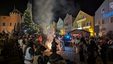 In Waldkirchen wird am 5. Januar die Rauhnacht gefeiert. Die Tradition gibt es in der Region seit 1725. Mit den geschnitzten Masken, dem alten Brauchtum Perchten, der auch im Süden des Bayerischen Waldes Tradition hat, werden die bösen Geister vertrieben. Die Alphörner spielen, es wird Brot verteilt und die guten Geister ziehen mit großem Lärm zum Marktplatz, berühren mit ihren Wedeln die Menschen und verjagen damit das ganze Böse. Am Marktplatz steht ein Galgen mit einer daran hängenden Strohpuppe, die das Böse darstellen soll. Mit dem Verbrennen der Puppe wird das Austreiben des Bösen symbolisch dargestellt. | Bild: BR, Bewegte Zeiten Filmproduktion GmbH