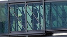 Menschen auf Gangway hinter Glaswand | Bild: BR; Montage: BR