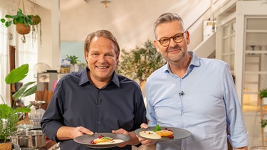 Björn Freitag (links) hat mit Sternekoch Thomas Martin spontan ein kreatives Gericht aus Resten zubereitet: Apfel-Beignets mit Madeira-Zabaione, Cranberrys und Nüssen. | Bild: WDR/2Bild TV.Events & Media GmbH/Christopher Nußbaumer