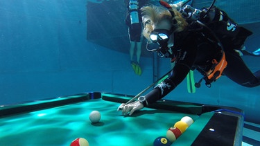 Die Weltrekord-Teilnehmerin Ulrike Winkler beim Billard spielen unter Wasser. | Bild: BR/south & browse GmbH/Helmut Wagenpfeil