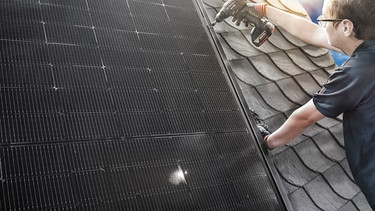 Vergangenheit trifft Zukunft: Mit dem neuen flachen Aufdach-Photovoltaiksystem von Rathscheck können jetzt auch bestehende Schieferdächer mit solarer Stromerzeugung einfach aufgerüstet werden. Die Befestigung erfolgt durch spezielle Solarhalter, die in die vorhandene Schieferfläche eingebunden werden. Durch die geringe Aufbauhöhe passen sich die dunklen PV-Module allen Schieferdeckarten an. Mit einer Haltbarkeit von 70 Jahren und mehr gehört der Naturstein Schiefer zu den langlebigsten Dacheindeckungen. Foto: Rathscheck / Weiterer Text über ots und www.presseportal.de/nr/19039 / Die Verwendung dieses Bildes für redaktionelle Zwecke ist unter Beachtung aller mitgeteilten Nutzungsbedingungen zulässig und dann auch honorarfrei. Veröffentlichung ausschließlich mit Bildrechte-Hinweis. Foto: Rathscheck/Rathscheck Schiefer/obs | Bild: dpa-Bildfunk/Rathscheck