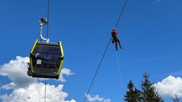 29.04.2024, Ochsenkopf (Fichtelgebirge) - Während einer Großübung wurden 320 Freiwillige in 32 Gondeln von der Bergwacht aus 20 Meter Höhe abgeseilt. Im Dezember 2023 war die Eröffnung der neuen Ochsenkopf-Seilbahn mit 10er Gondeln.  | Bild: BR/Markus Feulner