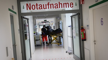 31.12.2023, Hamburg: Rettungssänitäter bringen einen Patienten in die Zentralen Notaufnahme im Albertinen Krankenhaus, während eines Besuchs von Hamburgs Bürgermeister Tschentscher im Rahmen seiner Silvestertour zum Jahreswechsel in der Klinik. Foto: Christian Charisius/dpa +++ dpa-Bildfunk +++ | Bild: dpa-Bildfunk/Christian Charisius