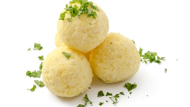 Drei Kartoffelknödel mit Petersilie bestreut liegen auf einer weißen Fläche. | Bild: stock.adobe.com/womue