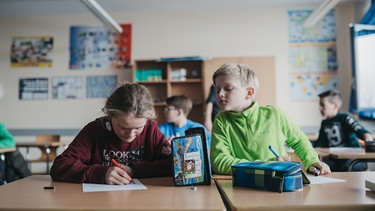 Ein Schüler schaut bei seinem Sitznachbarn ab. | Bild: BR/Julia Müller